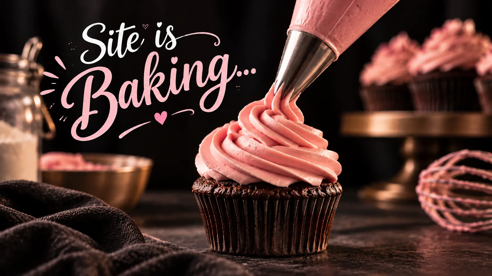 Site is Baking: a piping bag swirls pink frosting onto a chocolate cupcake.
